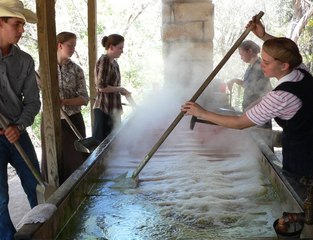 Cooking sorghum sap to make syrup.